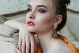 Stunning close-up portrait of a woman with elegant makeup and jewelry, epitomizing modern fashion and beauty.