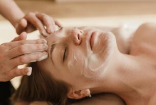 A close-up of a woman receiving a soothing facial massage with a skincare mask.