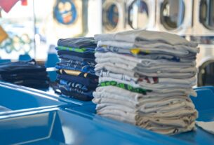 a stack of folded shirts sitting on top of a blue table